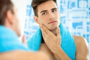 Handsome man looking at himself in the mirror