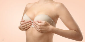 Female wearing a strapless bra holding both her breast